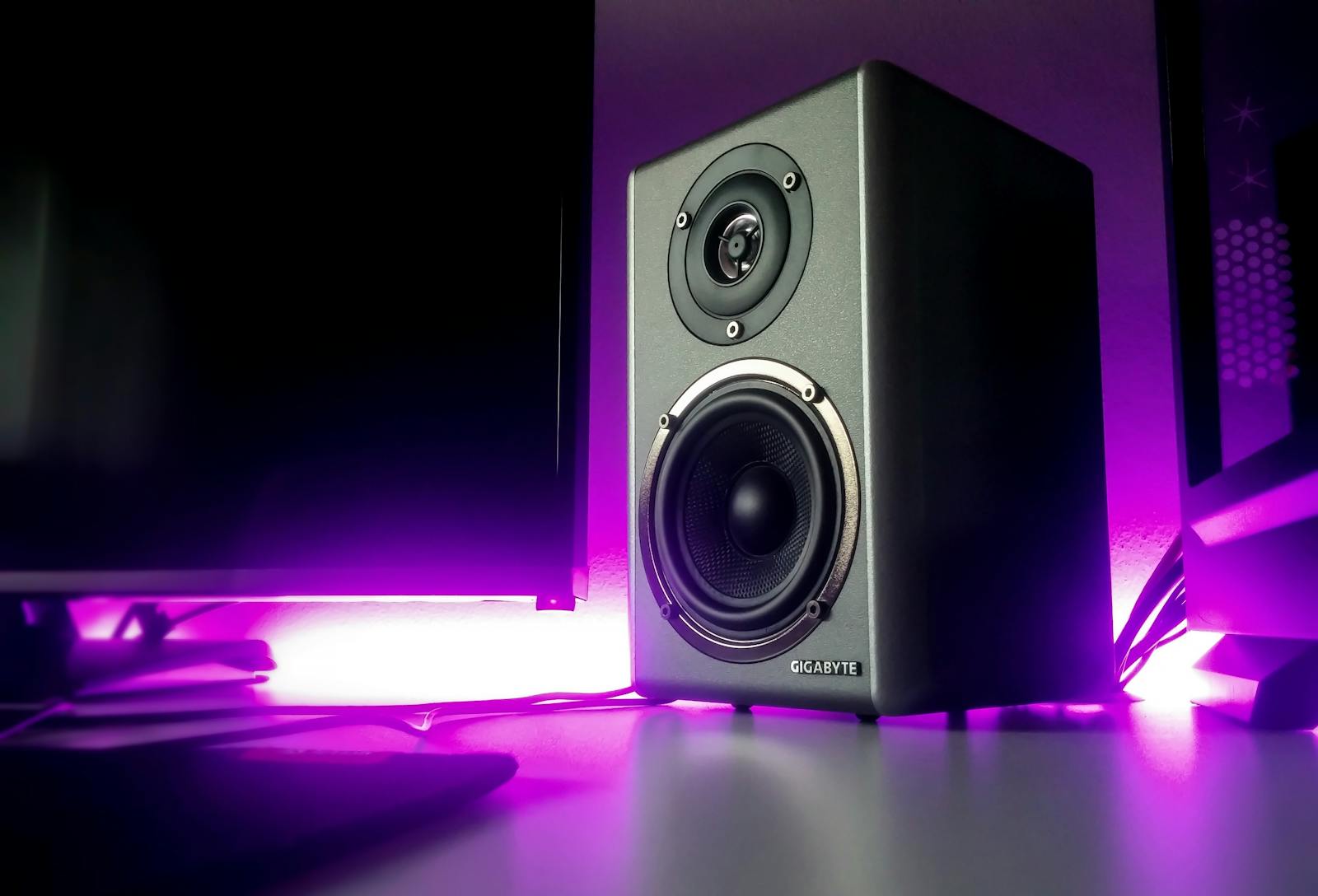 High-quality speaker setup with vibrant purple lighting in a modern studio setting.